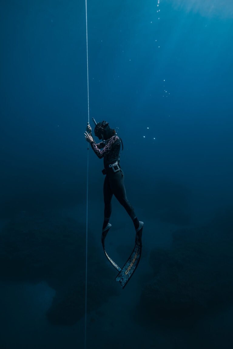 Freediver on training rope assisted by instructor